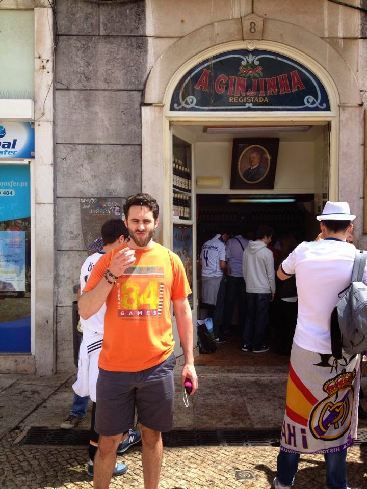 The author in front of 'A Ginjinha Bar' in Lisbon, Portugal, after taking a shot of the Portuguese liqueur, ginja.